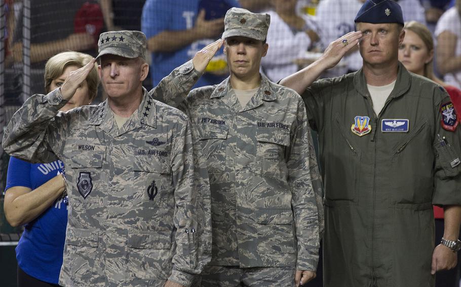 Gen. Stephen Wilson, left, vice chief of staff of the U.S. Air Force, salutes during the playing of the national anthem on Air Force Night at Nationals Park in Washington, D.C., Sept. 17, 2017.