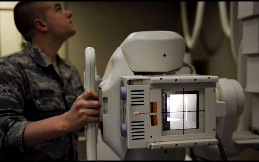 A video screen grab shows a military medical technician operating x-ray equipment. The Defense Health Agency says it has embraced and begun to adopt a host of recommendations to improve health care services for military children.