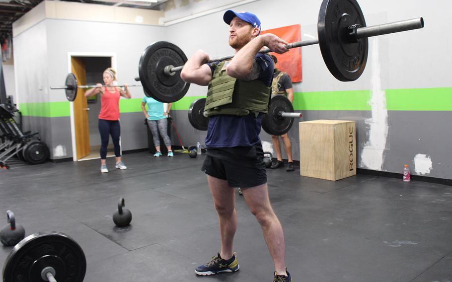 Brad Snyder, a former EOD technician and lieutenant in the U.S. Navy, lifts weights during a commemorative Workout at Coal Road Crossfit in La Planta, Md.