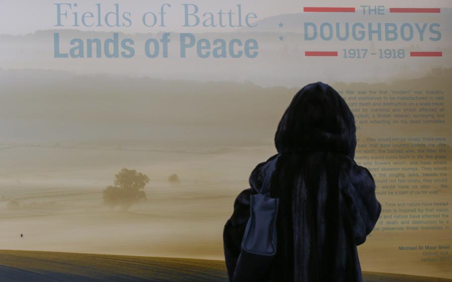A woman takes a moment at the World War I pictorial exhibit entitled "Fields of Battle, Lands of Peace: The Doughboys, 1917-1918," at Pershing Park in Washington, D.C., on Nov. 8, 2017. The exhibit showcases the battlefields of World War I as they look in modern times. 