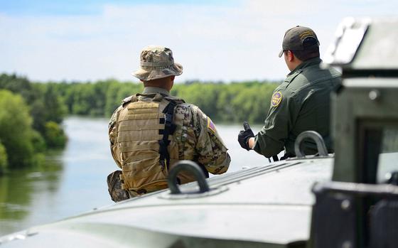 A Texas Guardsmen and a Customs and Border Patrol agent discuss the lay of the land April 10 on the shores of the Rio Grande River  in Starr County, Texas as part of the federal call-up to the Texas Mexico border. Soldiers called to duty at the border support federal partners and primarily serve in observe-and-report roles.