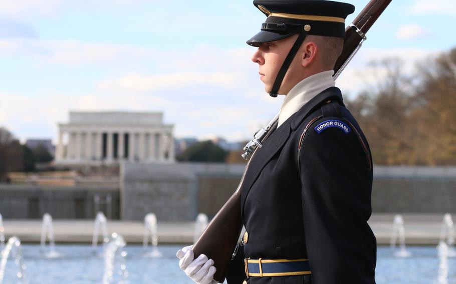 A member of the military color guard passes by the Lincoln Memorial as the guard retires the colors toward the end of a wreath-laying ceremony held in Washington, D.C., as part of the remembrance for the 76th anniversary of the Japanese attack on Pearl Harbor.  
