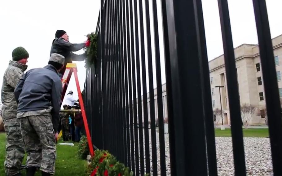 A video screen grab shows volunteers placing wreaths on a fence at the Pentagon's 9/11 memorial during a Wreaths Across America ceremony, Dec. 15, 2017.