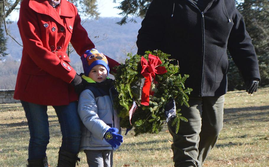Henry Solich, 3, helps Andrea Anderson and Ava Gift carry a wreath during the opening ceremonies of Wreaths Across America at Antietam National Cemetery in Sharpsburg, Md., December 16, 2017. Anderson and Gift are part of the American Legion Auxiliary and they helped raise funds for the event at Antietam.