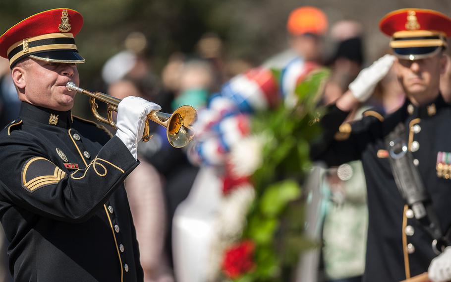 An Army bugler plays taps to conclude a special wreath-laying ceremony at Arlington National Cemetery's Tomb of the Unknowns on Friday, March 23, 2018.