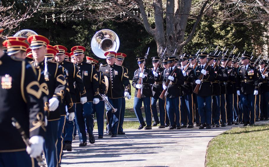Members of the United States Army Band, "Pershing's Own," and a ceremonial unit of soldiers march away from Arlington National Cemetery's Tomb of the Unknowns on Friday, March 23, 2018, following a special wreath-laying ceremony.