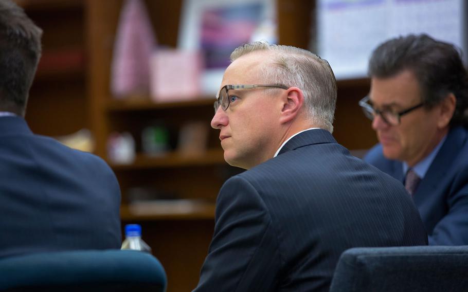 Navy Cmdr. John Michael Neuhart II, center, and his defense lawyer Kerry Armstrong listen as the prosecution questions a witness on the stand in this file image from Nov. 2017.