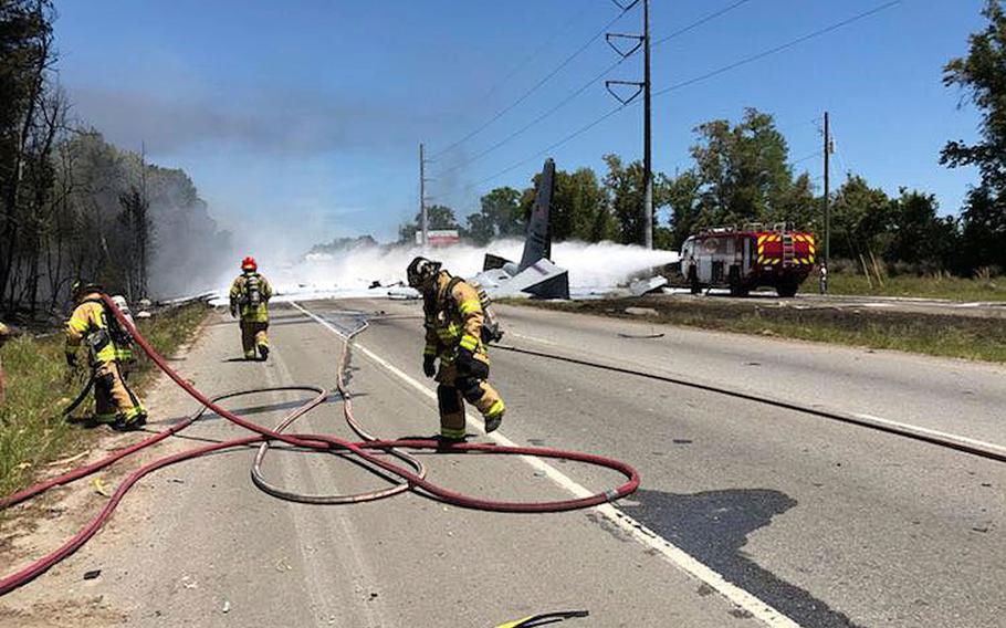 Firefighters work to extinguish a fire caused by a military cargo plane crash near the airport in Savannah, Georgia on Wednesday, May 2, 2018.