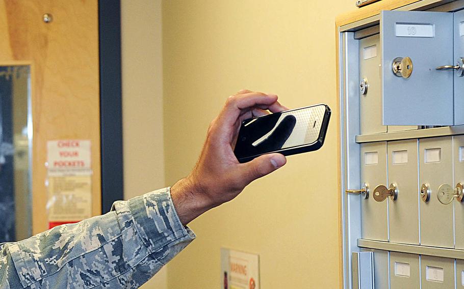 An airman puts his smartphone in a locker before entering the intelligence room at McConnell Air Force Base in Kansas on May 12, 2015.