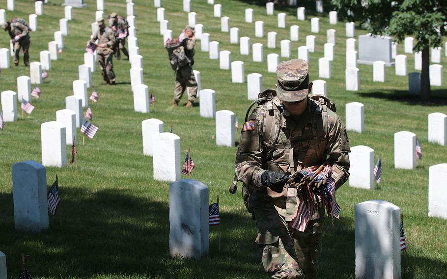 Soldiers with the 3d U.S. Infantry Regiment (The Old Guard) place flags in front of headstones at Arlington National Cemetery on Thursday, May 24, 2018. The annual pre-Memorial Day Flags-In ceremony has taken place every year since The Old Guard was designated as the U.S. Army's official ceremonial unit in 1948.