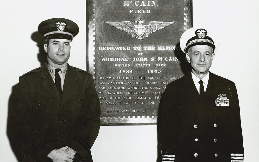 John McCain III, left, standing with his father, Adm. John S. McCain Jr., right, in front of a plaque dedicated to McCain’s grandfather Adm. John McCain Sr.