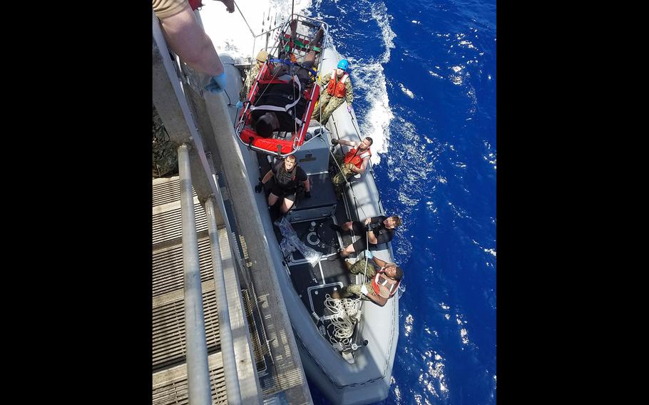 A man rescued at sea is lifted on a stretcher onto the USNS Trenton, in the Mediterranean Sea on Tuesday, June 12, 2018. 