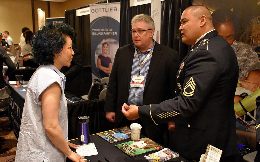 Sgt. 1st Class James Guevarra, U.S. Army health care recruiter with the Las Vegas Medical Recruiting Station, and Bruce Schamburek, education services specialist for 6th Medical Recruiting Battalion, speak to an attendee of the Essentials of Emergency Medicine workshop at the Cosmopolitan Hotel in Las Vegas on May 15, 2018.