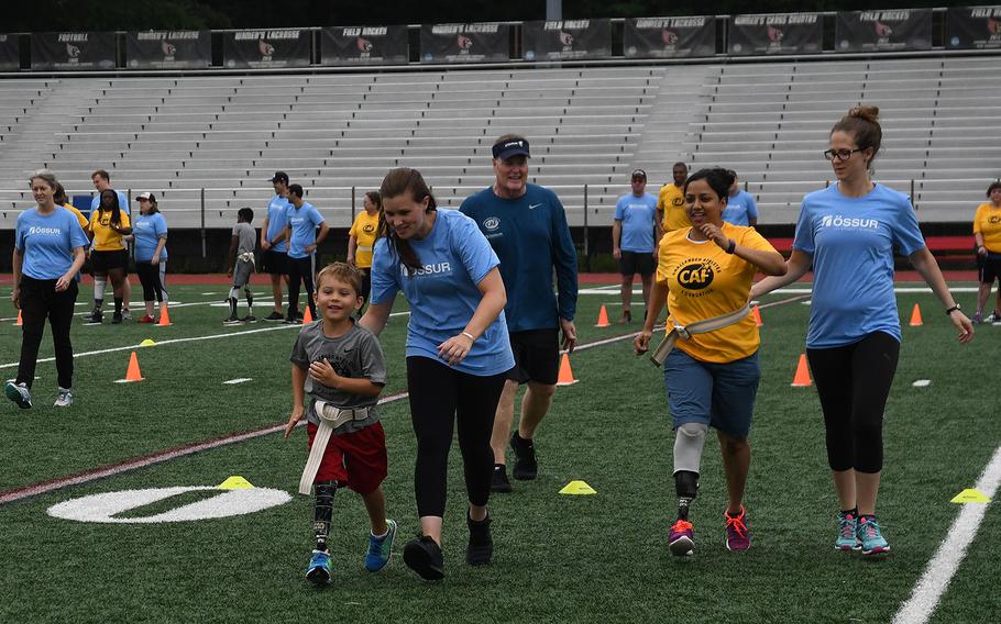 5-year-old Nathan Simm was practicing with his prosthetic leg at the Challenged Athletes Foundation clinic on June 23, 2018. Each athlete was paired up with a volunteer to help them at the event. Volunteers wore blue shirts and athletes wore yellow shirts. 