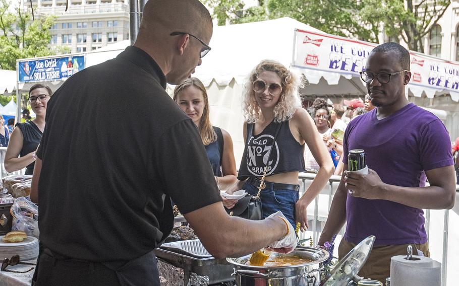 Master Sgt. Leland White dishes out some food at the Military Cook-Off at the 2018 Giant National Capital Barbecue Battle, Sunday, June 24, 2018. White has served for 18 years in the Marines and will be leaving the service in 23 months. 