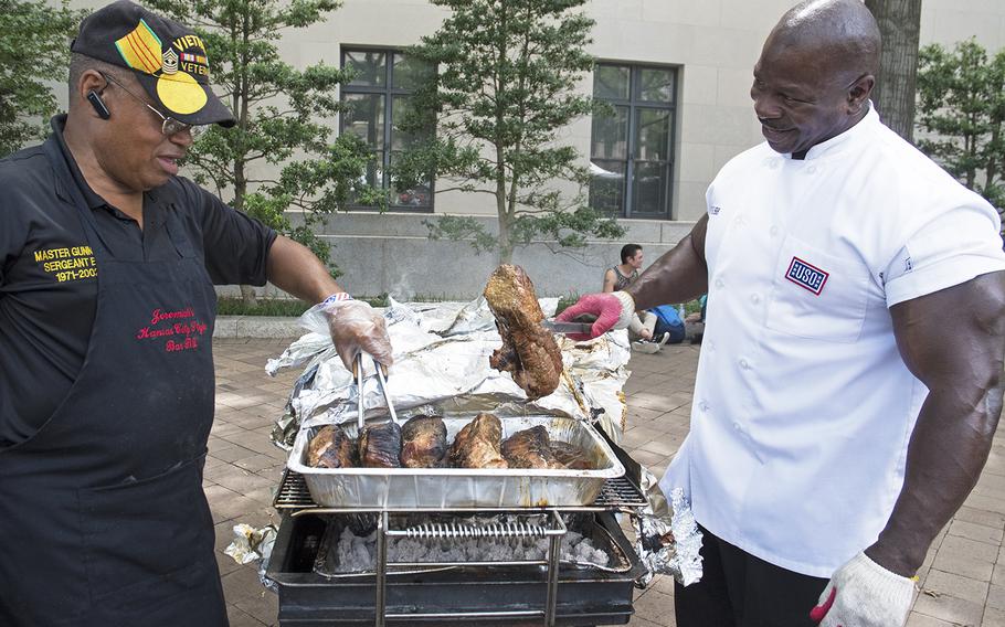 Ret. Marine Master Gunnery Sgt. Jeremiah Burns, left, and Ret. Army Master Sgt. Andre Rush check the progress of their pork tenderloins during the Military Cook-Off at the 2018 Giant National Capital Barbecue Battle, Sunday, June 24, 2018.