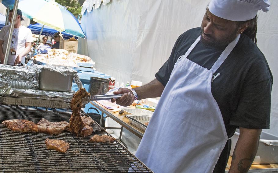 Danell Mengesha, a student at Stratford University and an Army veteran, works on the pork tenderloin at the
Military Cook-Off at the 2018 Giant National Capital Barbecue Battle, Sunday, June 24, 2018. Mengesha served from 2004-2007. 