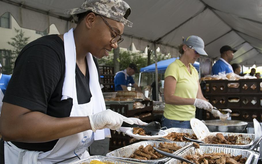 Army veteran Sgt. Fallon Williams, from the Stratford University Woodbridge campus, dishes out some pork tenderloins at the Military Cook-Off at the 2018 Giant National Capital Barbecue Battle, Sunday, June 24, 2018. Williams served 14 years.