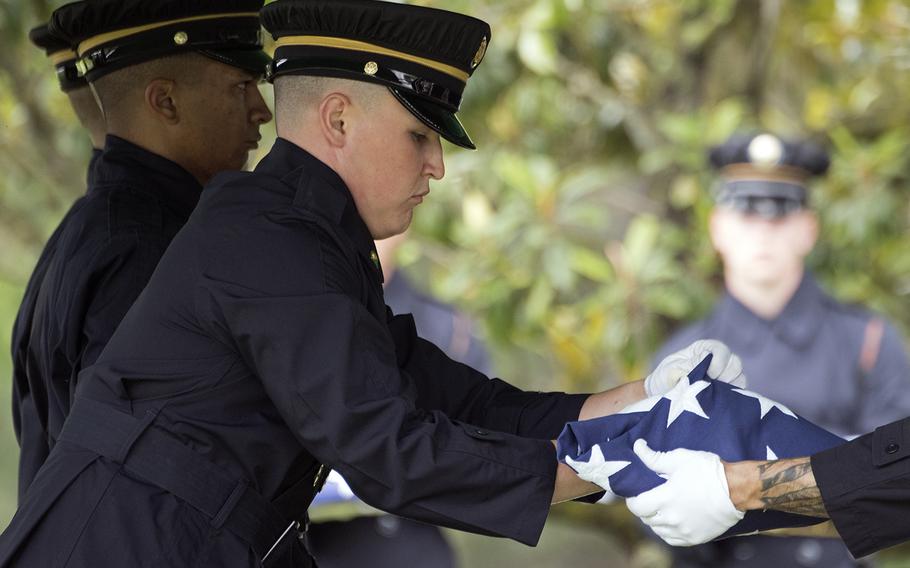 The Old Guard fold a flag over the coffin of Staff Sgt. Robert Shoemaker during a funeral at Arlington National Cemetery for five airmen killed during World War II on June 27, 2018.

