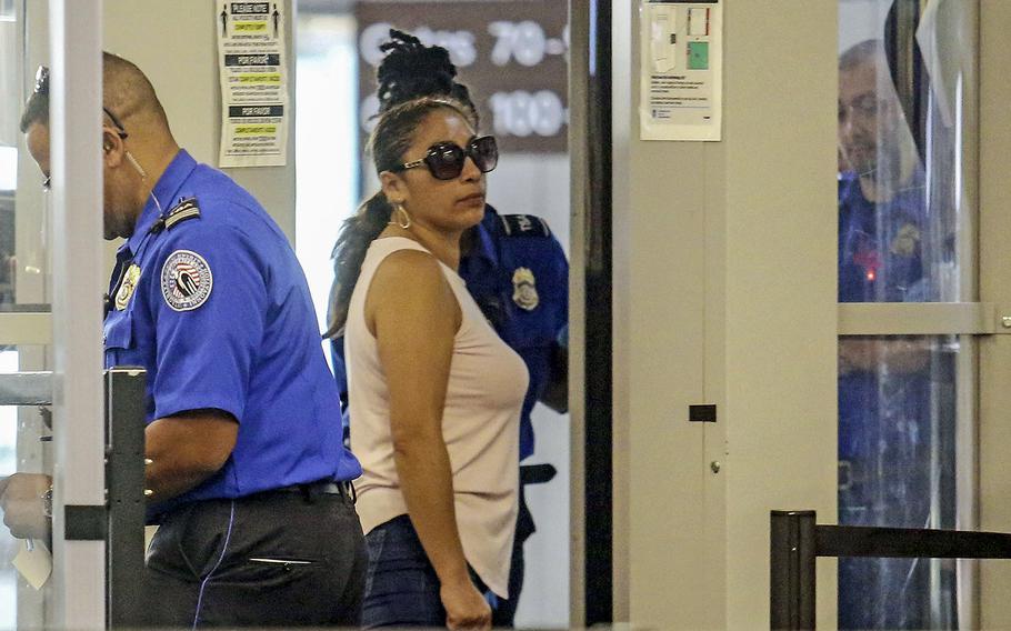 Alejandra Juarez, 38, center, passes through TSA screening at the Orlando International Airport on Friday, Aug. 3, 2018 in Orlando, Fla.  Juarez, the wife of a former Marine is preparing to self-deport to Mexico in a move that would split up their family.