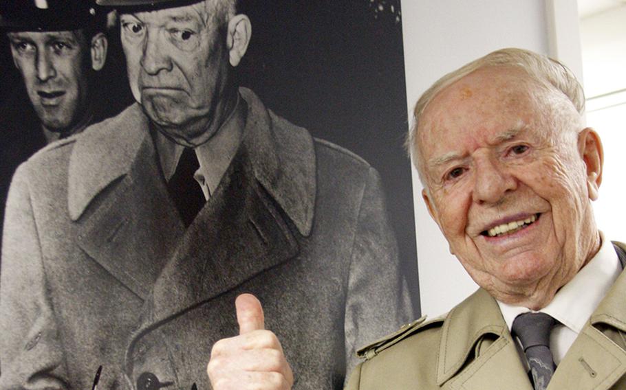 Francis "Red" Grandy poses next to a portrait he took of Dwight D. Eisenhower. Grandy, a longtime Stars and Stripes photographer, died Sunday, Aug. 5, 2018. He was 96.