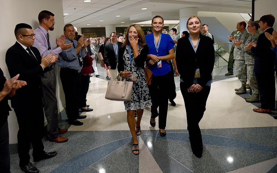 Valerie Nessel, the spouse of U.S. Air Force Tech. Sgt. John Chapman and other family members receive a standing ovation at the Pentagon in Arlington, Virginia on Aug. 21, 2018. 