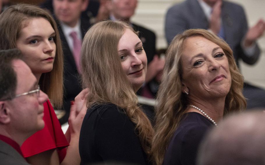 Valerie Nessel, right, the widow of Tech. Sgt. John Chapman, and daughters Madison, and Brianna Chapman, watch as servicemembers are introduced during a Medal of Honor ceremony at the White House, Aug. 22, 2018.