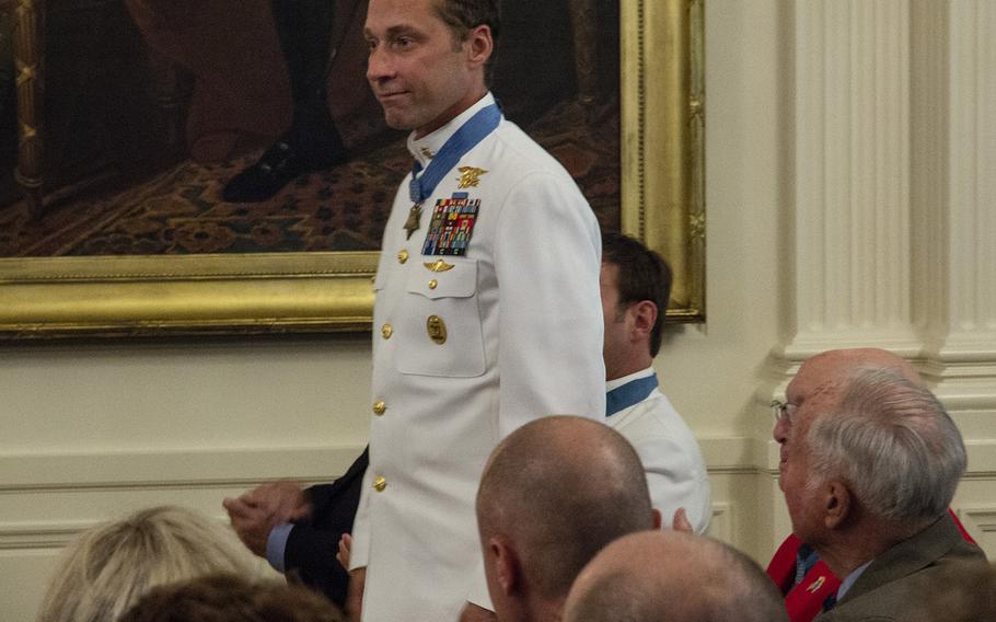 Medal of Honor recipient Master Chief Petty Officer Britt Slabinski stands as he's recognized by President Donald Trump during a ceremony at the White House, Aug. 22, 2018.