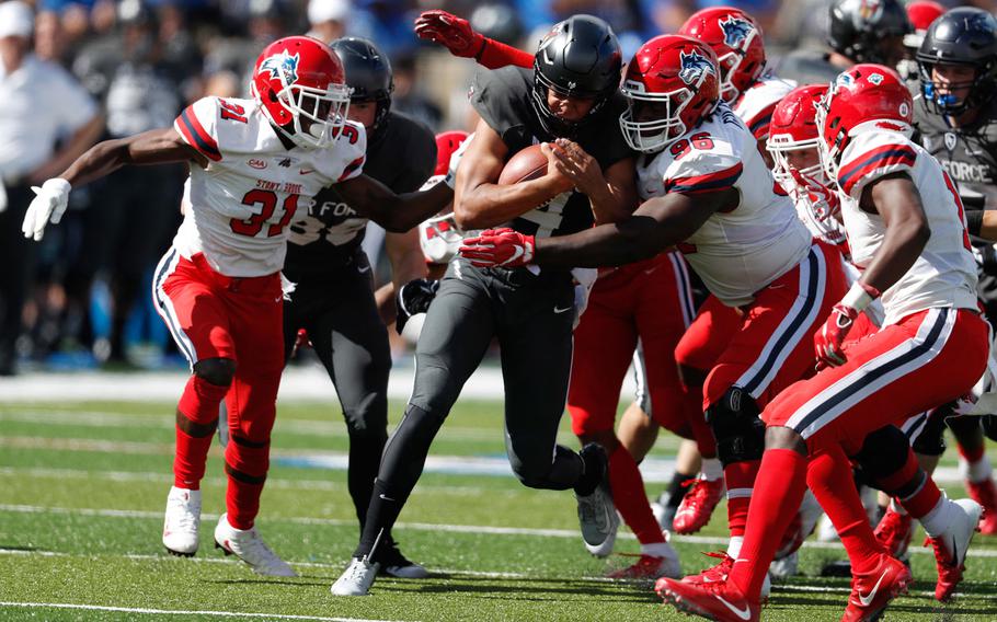 Air Force quarterback Isaiah Sanders, second from left, is stopped after a short gain by, from left, Stony Brook defensive back Kareem Gaulden, defensive lineman Odean Gilzene and defensive back Gavin Heslop in the second half of an NCAA college football game Saturday, Sept. 1, 2018, at Air Force Academy, Colo. Air Force won 38-0.