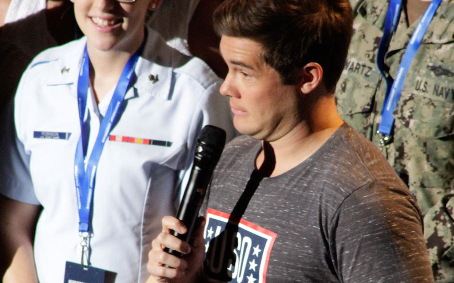 Comedian Adam Devine tells a joke during his opening dialogue at "The World's Biggest USO Tour" at The Anthem theater in Washington on Wednesday, Sept. 12, 2018.