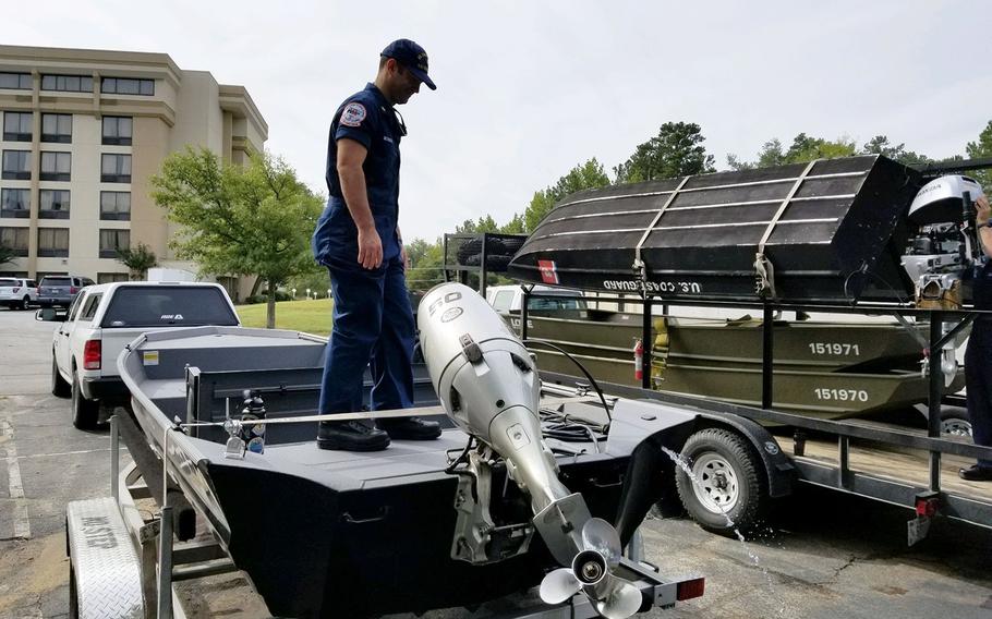 Petty Officer 1st Class Mike McHugh from the Coast Guard Gulf Strike Team checks the outboard engine of one of the Shallow Water Urban Search and Rescue boats staged in Augusta, Georgia, Sept. 13, 2018 in preparation for Hurricane Florence.