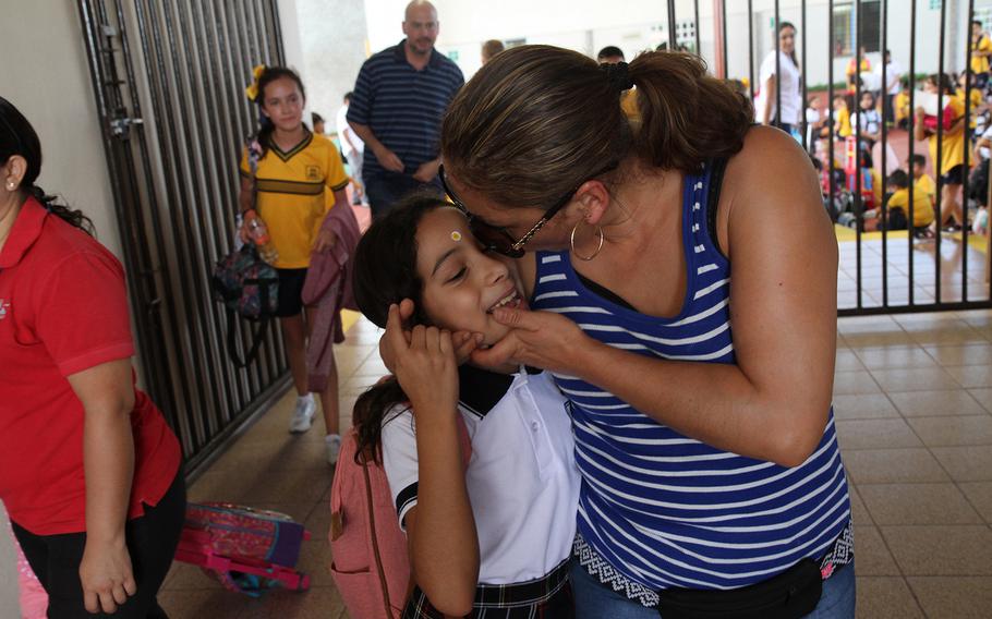 Alejandra Juarez, right, kisses her daughter Estela, 9, as she picks her up from her new school in Mexico's Yucatan on Aug. 30. Juarez was deported on Aug. 3, after 22 years in the U.S., where she built a home and family with her husband, an Iraq War veteran.