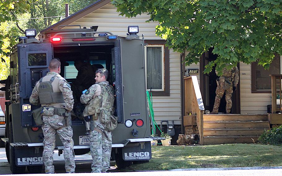 Law enforcement officers participate in an operation at a home in Logan, Utah on Wednesday, Oct. 3, 2018. A man suspected of mailing suspicious letters to the Pentagon and White House was taken into custody at the scene. 