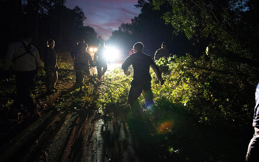 Members of the Florida National Guard's Chemical, Biological, Radiological, Nuclear, High Yield Explosive Enhanced Response Force Package (CERF-P) team clear debris from the road after Hurricane Michael on Oct. 11, 2018.