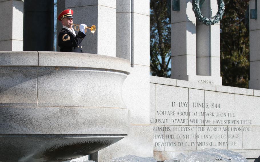 A soldier plays taps at a ceremony honoring World War II veterans at the National World War II Memorial in Washington, D.C., on Sunday, Nov. 11, 2018.