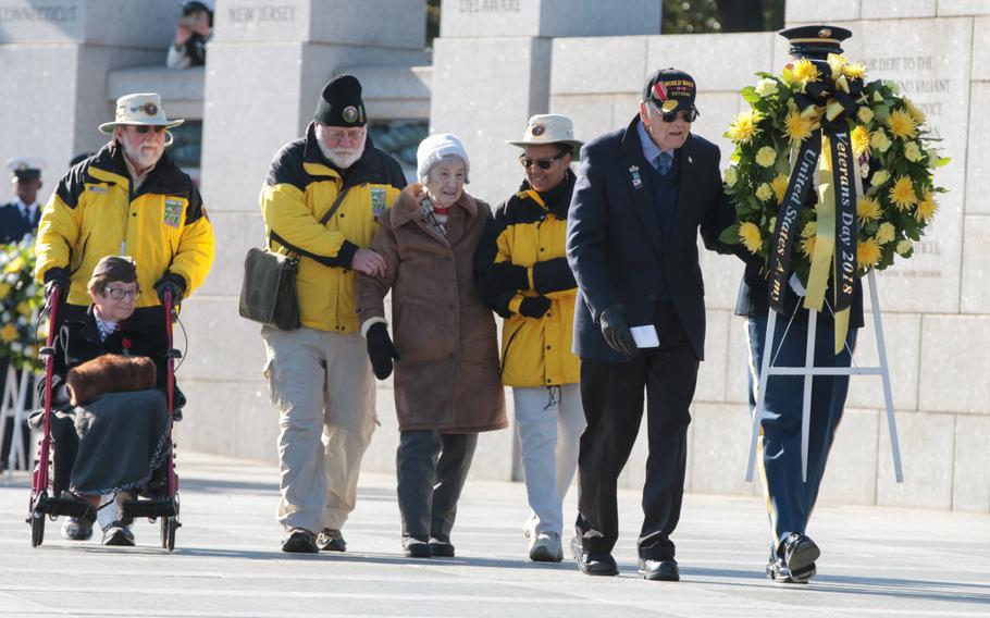 Volunteers help World War II veterans lay a wreath at a Veterans Day ceremony held at the National World War II Memorial in Washington, D.C., on Sunday, Nov. 11, 2018.