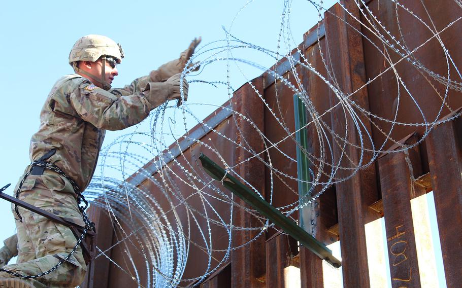 Pfc. Nicholas Young, 87th Sapper Company, places concertina wire on the Arizona-Mexico border wall, Nov. 10, 2018. 