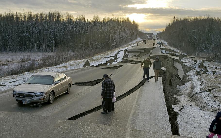 People walk along Vine Road after an earthquake on Friday, Nov. 30, 2018, in Wasilla, Alaska.