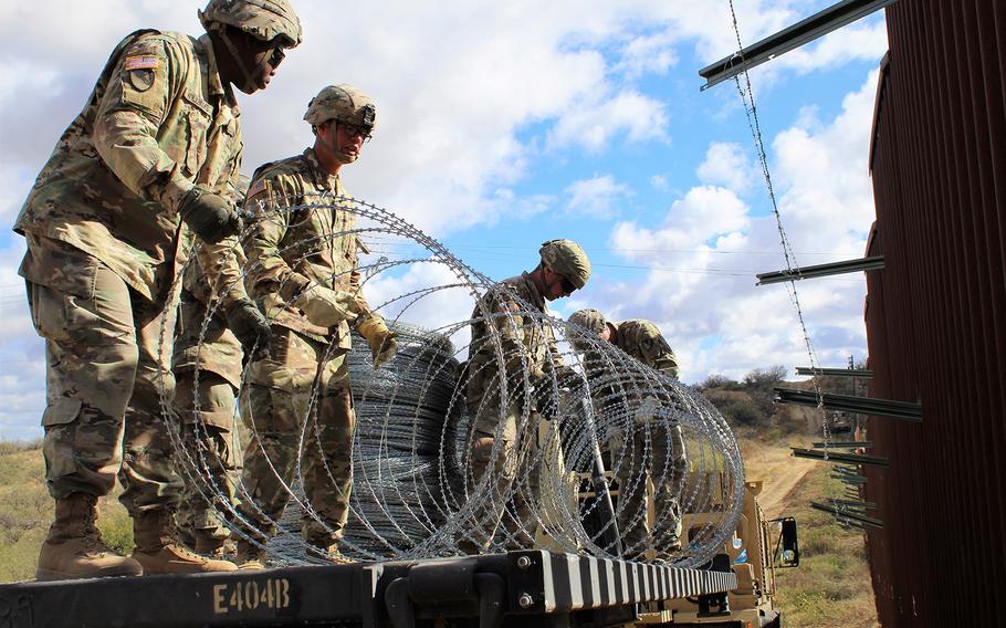 Engineers from 937th Clearance Company prepare to place concertina wire on the Arizona-Mexico border wall, Dec. 1, 2018. 