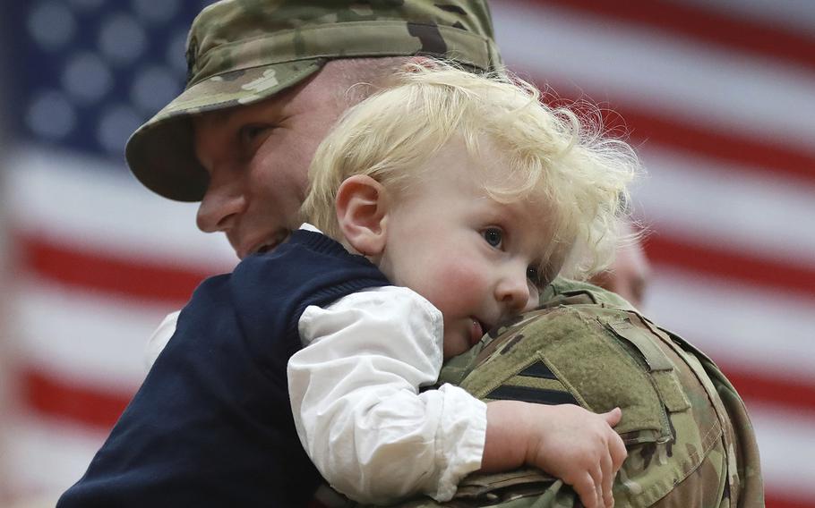 Lt. Col. Nate Stone hugs his one-year-old son Conrad during the Georgia National Guard's 48th Brigade Combat Team Casing of Color and Departure Ceremony for their deployment to Afghanistan on Friday, Dec 21, 2018, at Fort Stewart, Ga.