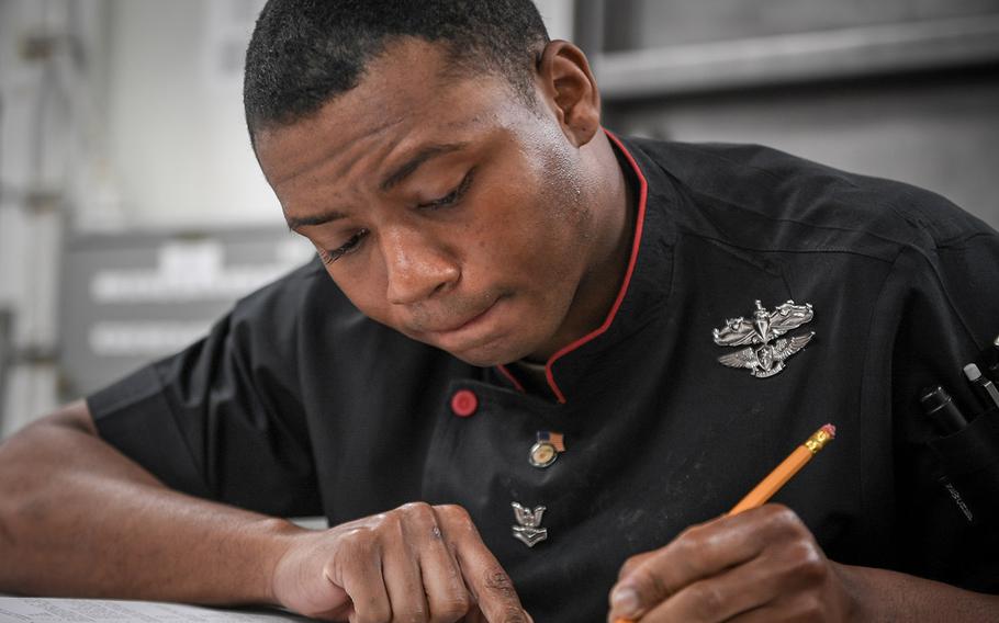 In a September 6, 2018 file photo, Culinary Specialist 2nd Class Darien Whitfield takes the Navy-wide 1st Class advancement exam on the mess decks of the guided-missile destroyer USS Jason Dunham. The lead-up to the exam is going to get easier, thanks to the automation of the enlisted advancement worksheet.
