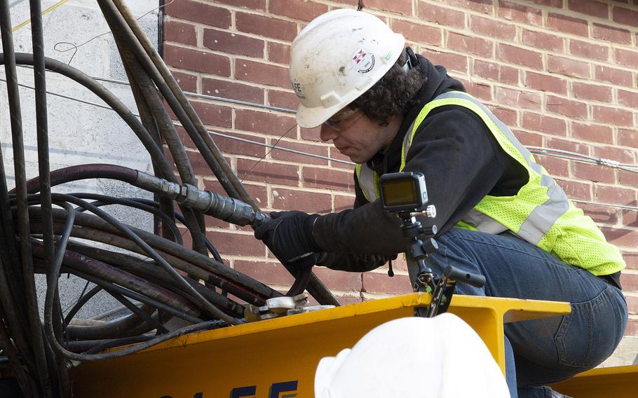 A worker adjusts the cables on a crawler being used to move Washington's oldest synagogue building on January 9, 2019.