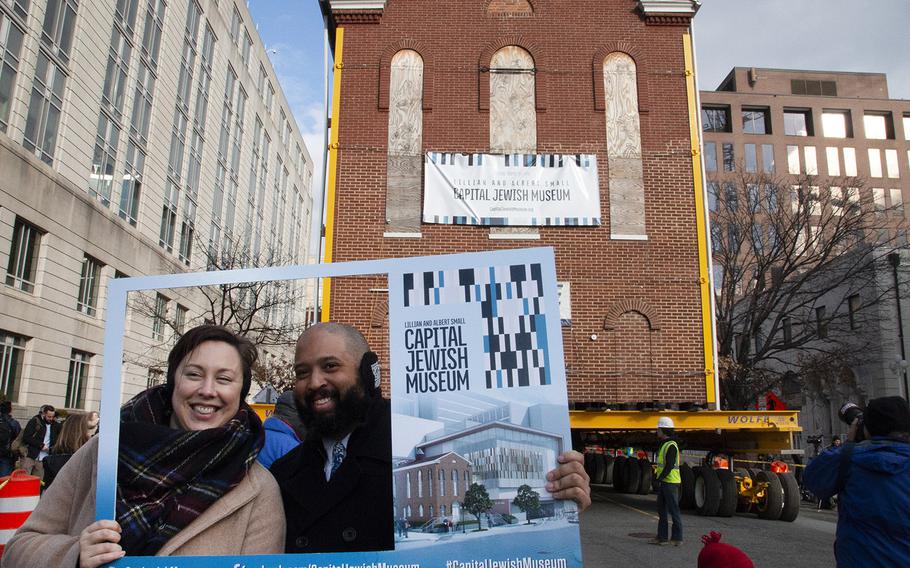 Spectators pose for a photo as Washington's oldest synagogue building is moved down 3rd St. Northwest to its permanent location at the Lillian and Albert Small Jewish Museum site on January 9, 2019.