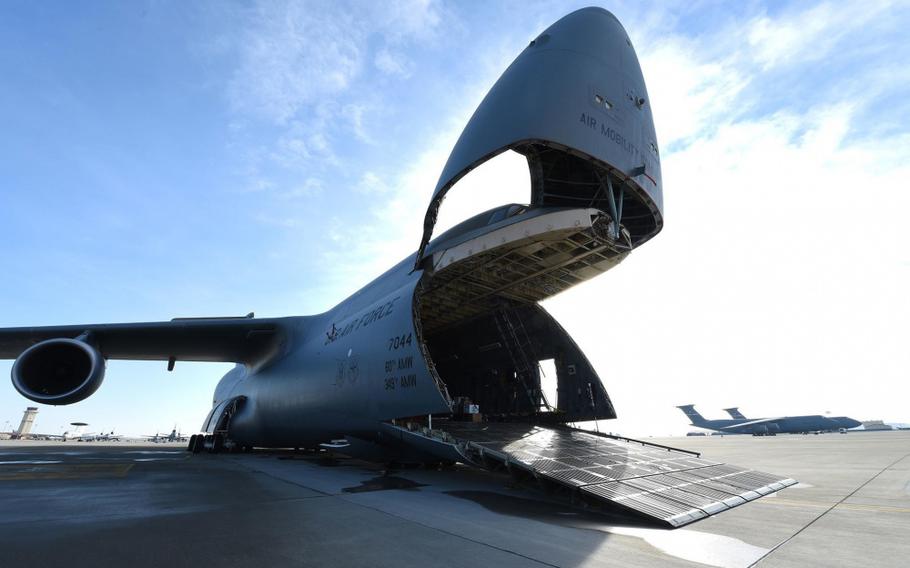 An Air Force C-5M Super Galaxy is readied to load four U.S. Army UH-60 Black Hawk helicopters as a part of a training mission Jan. 13, 2019, at Travis Air Force Base, Calif.