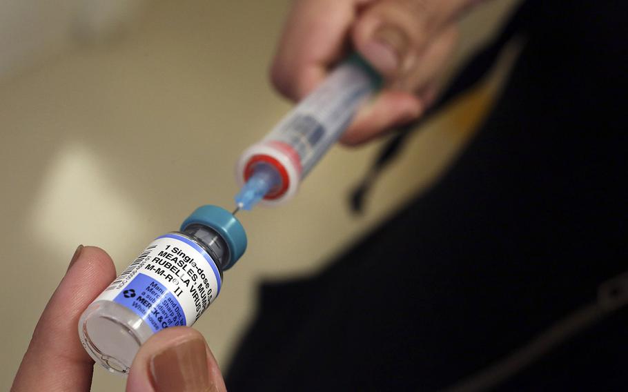 In a 2015 file photo, a vial containing measles vaccine is loaded into a syringe before being given to a baby at the Medical Arts Pediatric Med Group in Los Angeles.