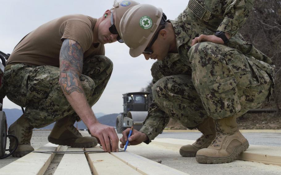 Seabees assigned to Naval Mobile Construction Battalion 3 measure wood to create formwork to place a concrete pad at Somodo Pier 11 onboard Commander, Fleet Activities Chinhae on Feb. 27, 2019. N