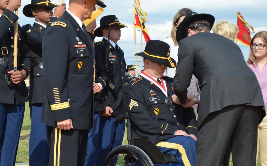 Chris Widell pins the Distinguished Service Cross on retired Sgt. Daniel Cowart during a ceremony March 20 at Fort Hood, Texas. Widell is a former Army officer and friend who Cowart said helped him regain confidence and purpose after being wounded in combat. Cowart received an upgrade from the Silver Star medal after a review of his actions on May 13, 2007, in Samarra, Iraq.