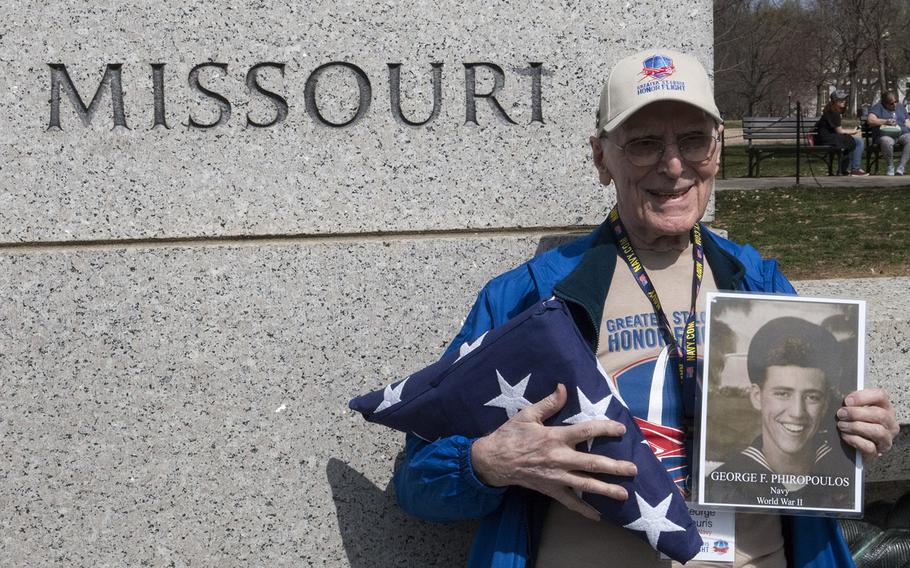 Greater St. Louis Honor Flight participant and Navy veteran George Souris holds a photo of his daughter's father-in-law, Frank Phiropoulos, as he stands at the Missouri pillar at the National World War II Memorial in Washington, D.C., March 30, 2019.