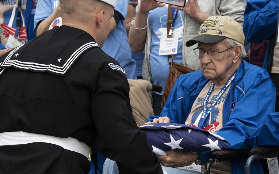 A member of the ceremonial guard presents Army Air Corps veteran Bud Jones with a flag during the Greater St. Louis Honor Flight's visit to the National World War II Memorial in Washington, D.C., March 30, 2019.