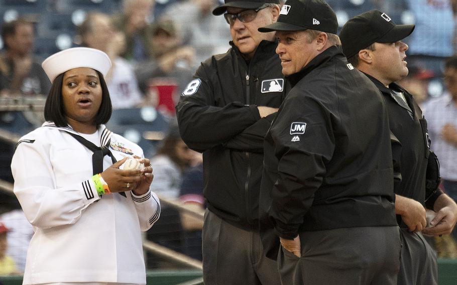 Yeoman 1st Class Whitney Sisson stands with hte umpires as she prepares to present the game ball to Washington Nationals catcher Yan Gomez during Navy Night ceremonies at Nationals Park in Washington, D.C., May 1, 2019.